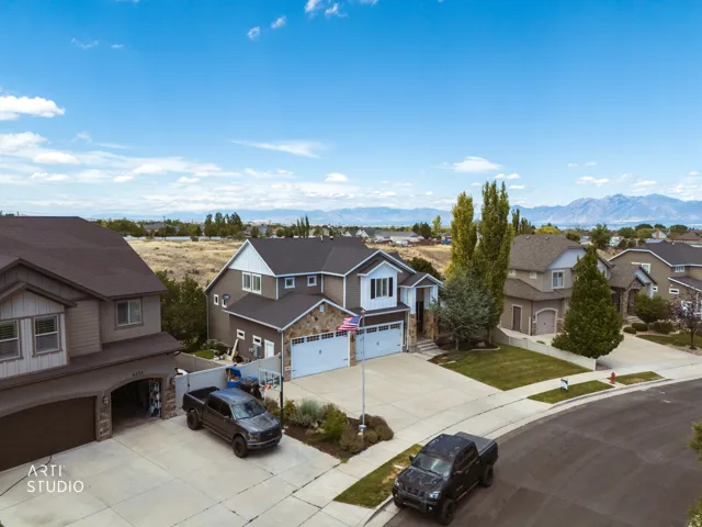 Contemporary two-story residence featuring a two-car garage, stone and siding exterior, and a paved driveway