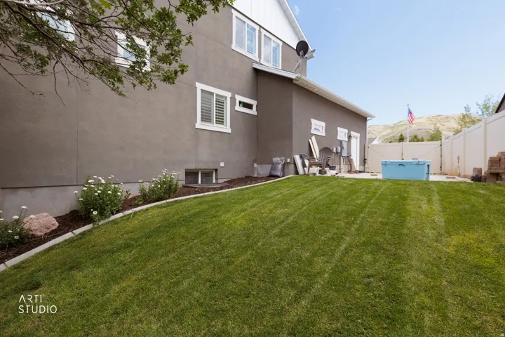 Expansive grassy yard with a concrete patio