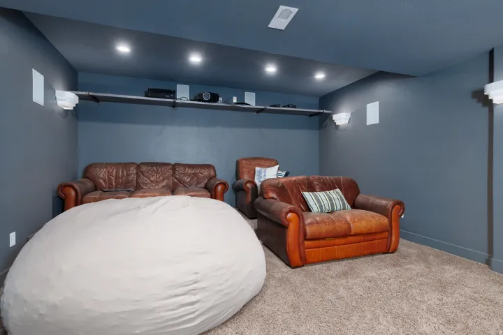 Dedicated entertainment room featuring recessed ceiling lighting and wall-mounted sconces