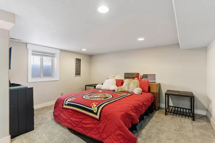 Carpeted room with recessed lighting and a window featuring horizontal blinds