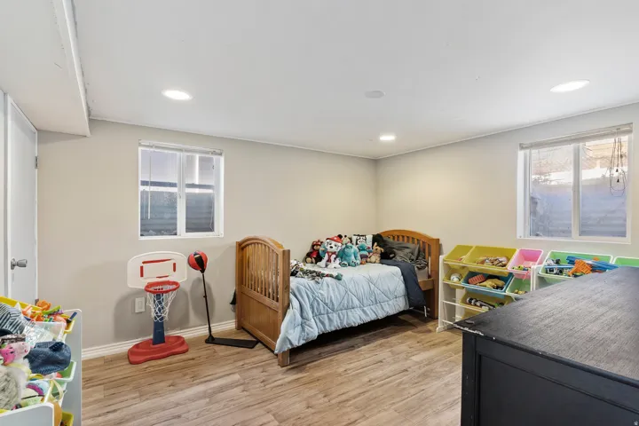 Well-lit room featuring recessed lighting, two windows, wood-finish flooring, and light-toned walls