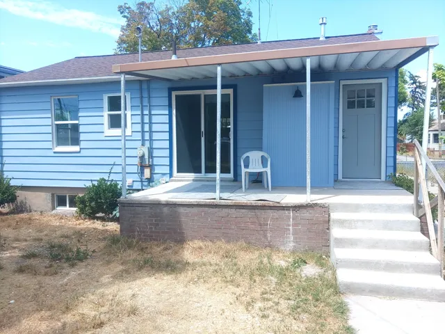 Rear exterior with light blue siding featuring a covered patio area