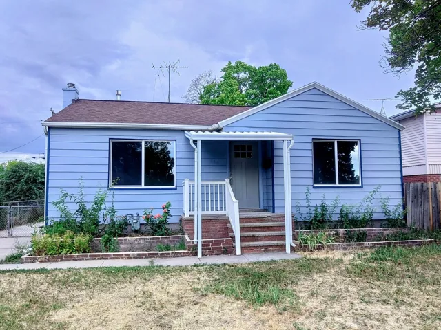 Blue siding exterior featuring a covered porch entrance and a brown asphalt shingle roof