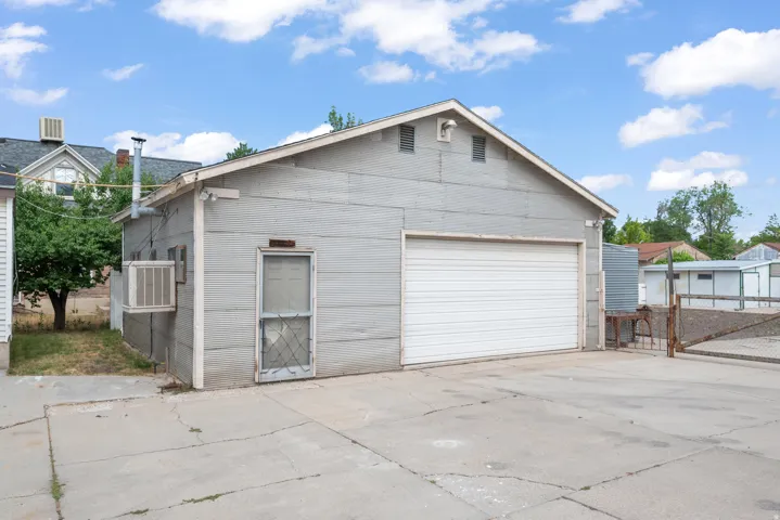 Detached garage structure with a single garage door and an exterior workshop entry door