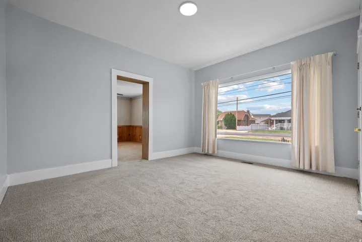 Spacious Great Room featuring new paint and carpet with a large front viewing window.
