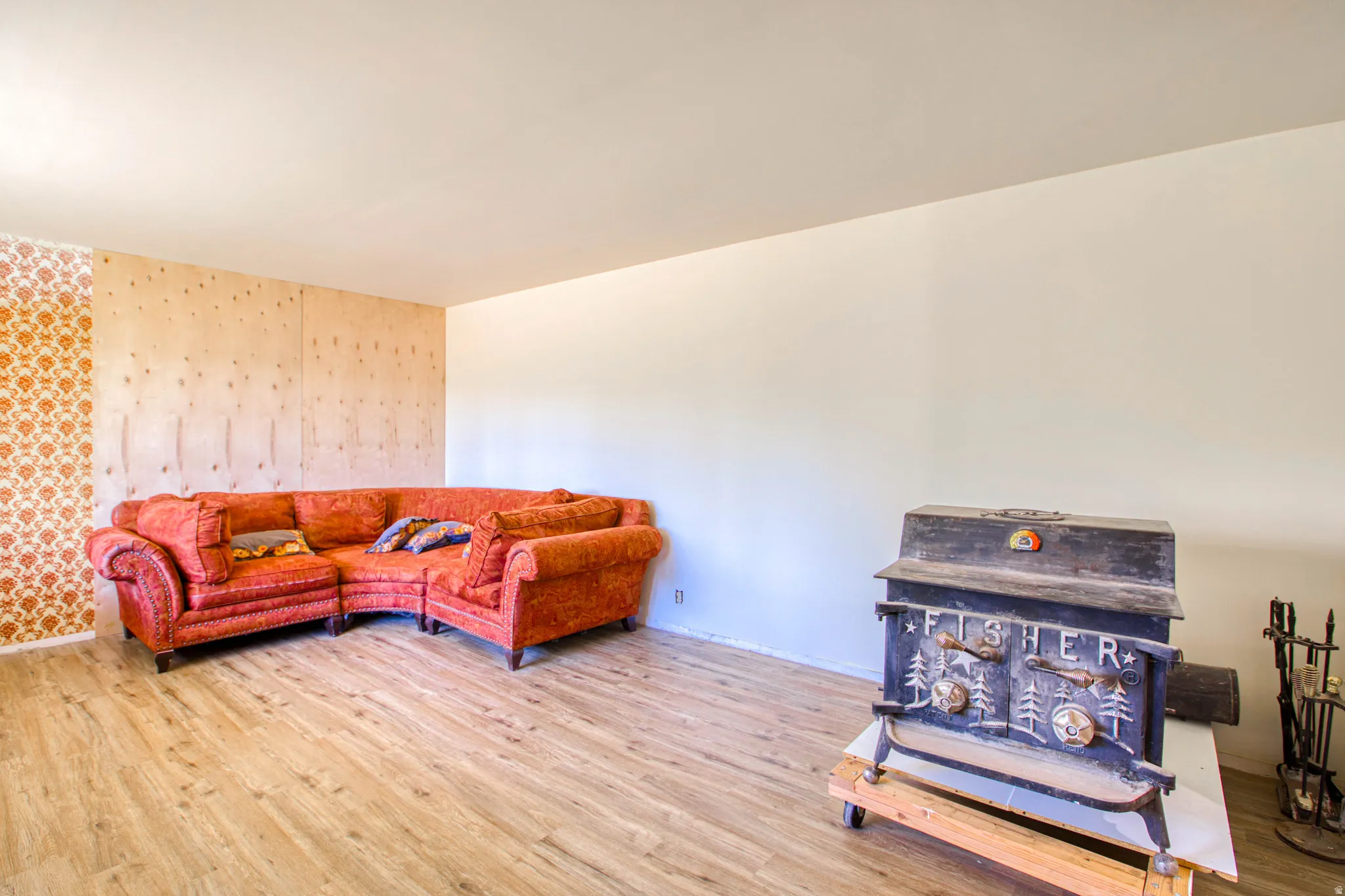 Living area featuring wood-finish flooring and a cast iron wood stove
