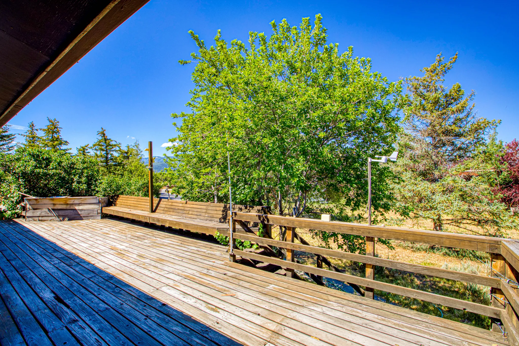 Expansive wood deck with a built-in wood bench and railing
