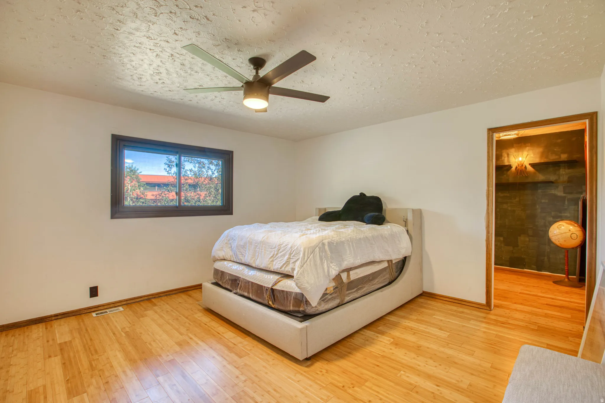 Wood-finish flooring throughout, complemented by a ceiling fan with integrated lighting