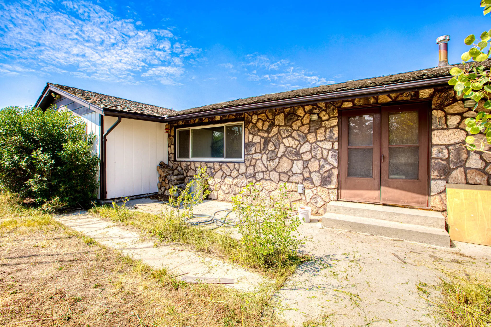 Stone veneer exterior with a concrete patio