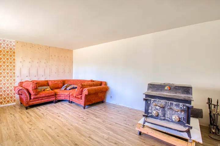 Living area featuring wood-finish flooring and a cast iron wood stove