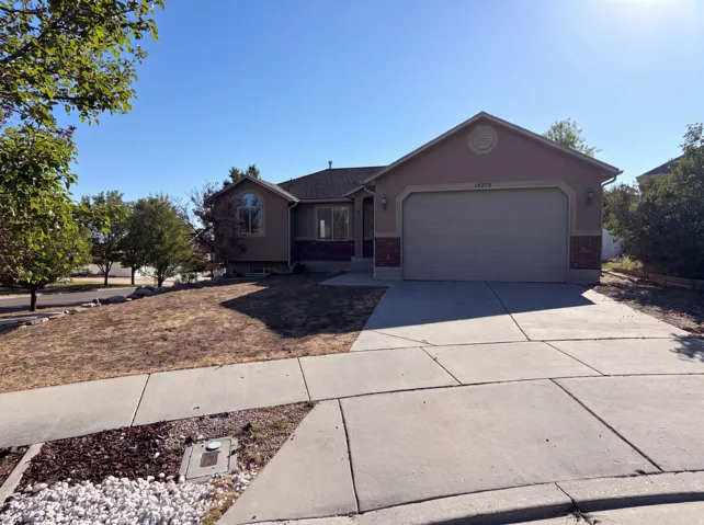 Stucco exterior featuring brick accents and an attached garage
