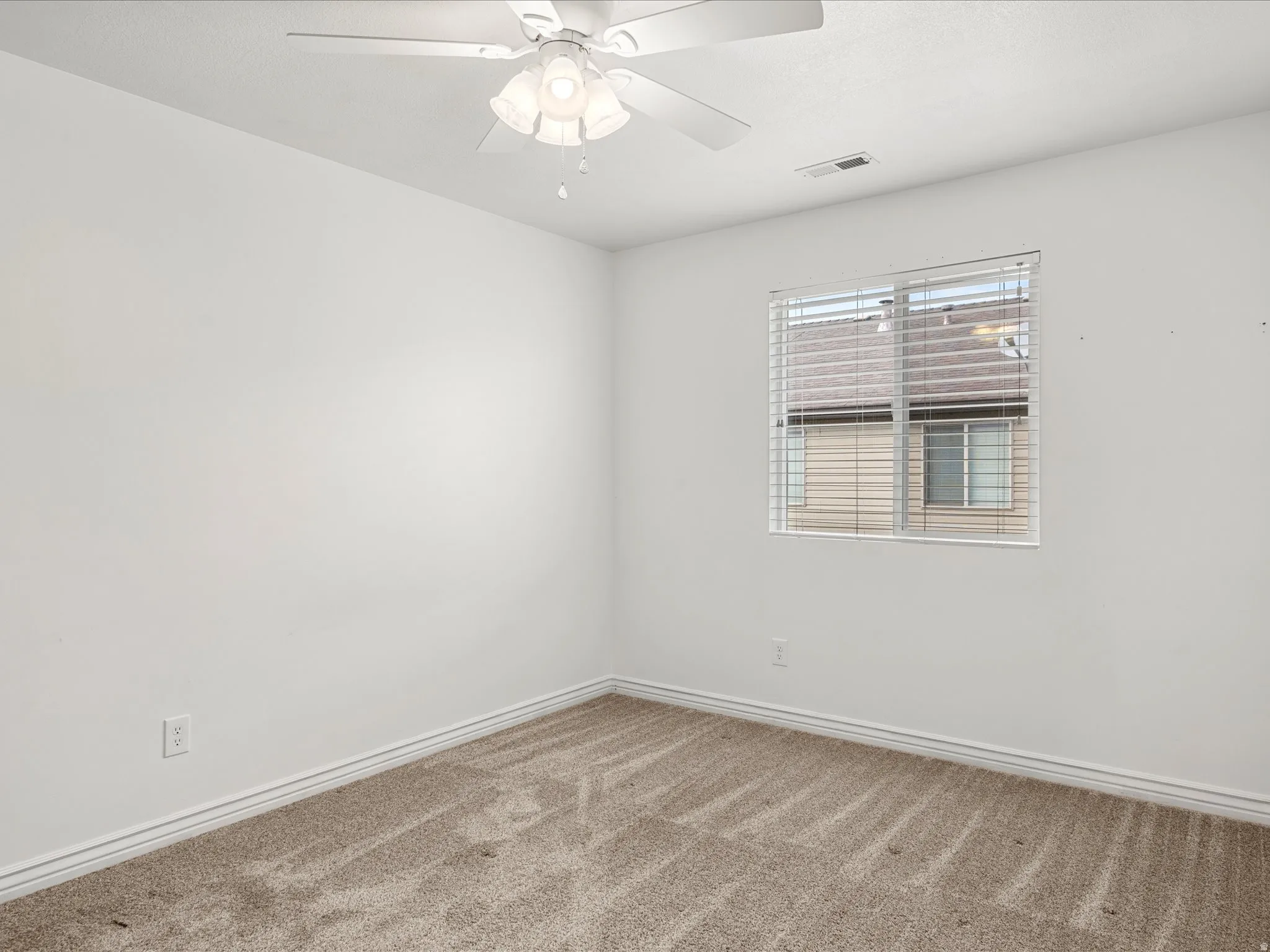 Bedroom featuring neutral carpeting, white walls, and a ceiling fan with integrated lighting