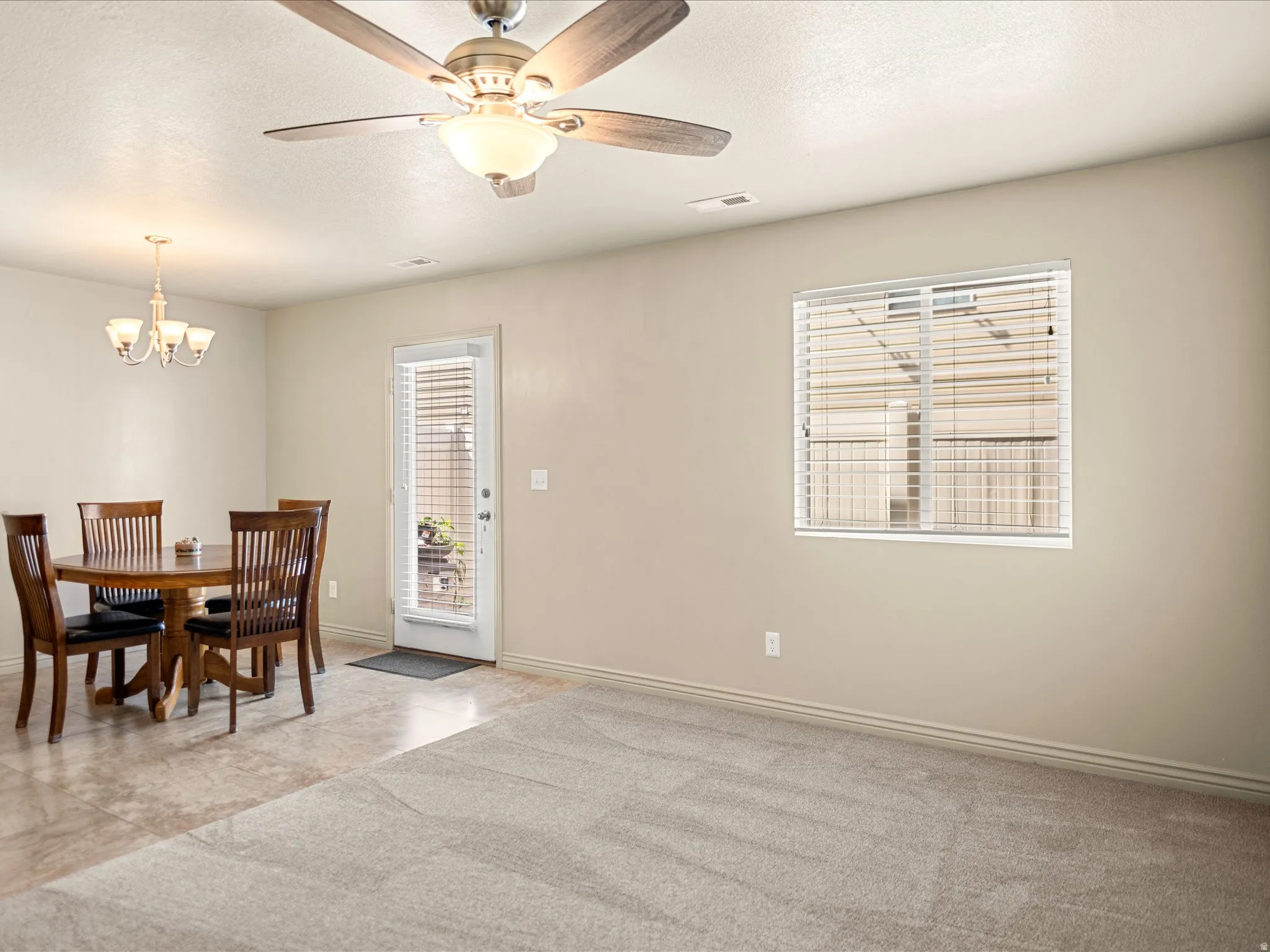 Neutral-toned walls complement the carpeted living area and tiled dining space