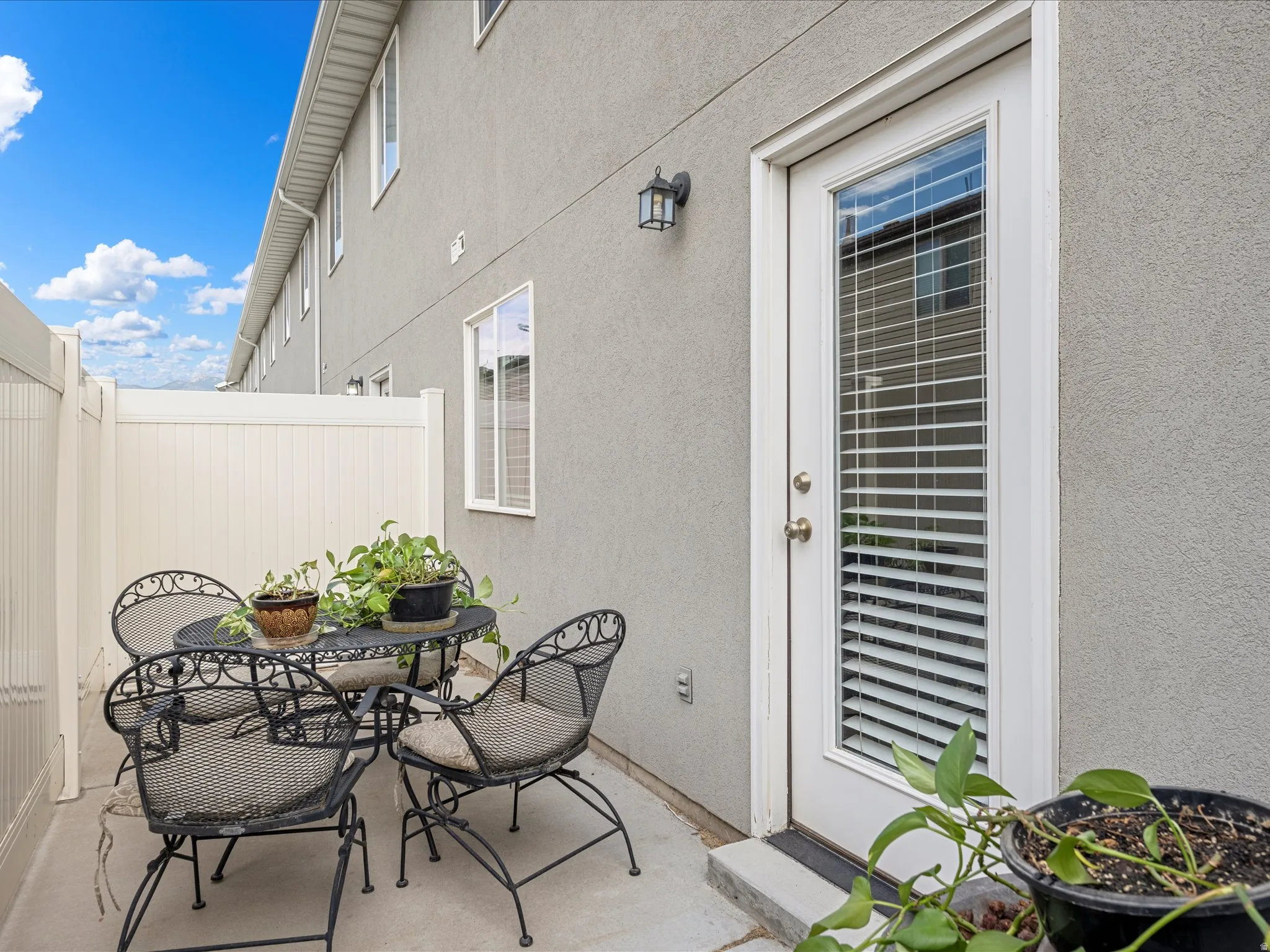 Private concrete patio area featuring a sturdy vinyl fence