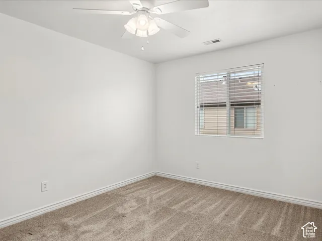 Bedroom featuring neutral carpeting, white walls, and a ceiling fan with integrated lighting