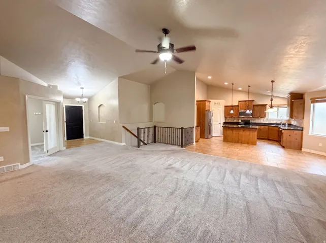 Open-concept living space featuring vaulted ceilings and a ceiling fan