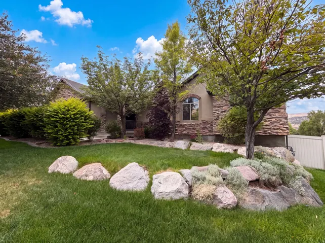 Stone-clad home with a stucco facade and arched window details