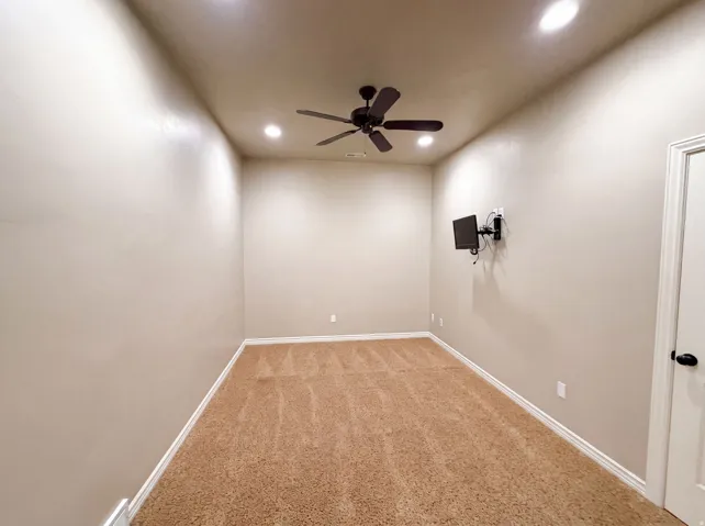 Neutral-toned walls complement the textured brown carpet flooring