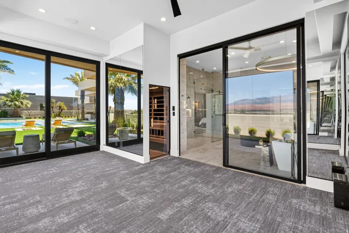 Sliding glass doors opening to an outdoor living area with a swimming pool and artificial turf