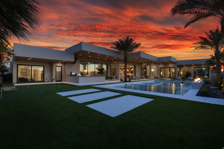 Contemporary exterior with expansive artificial turf, a putting green, and large format patio pavers