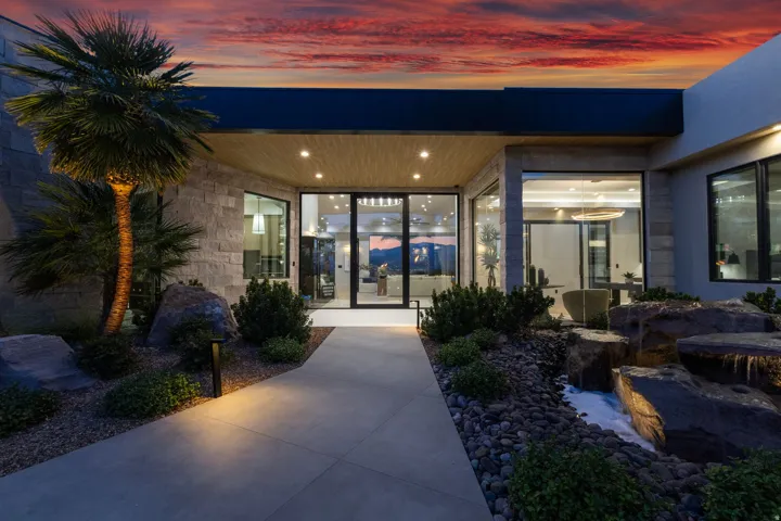 Modern architectural exterior with extensive glass paneling, stone accents, and a distinctive wood-finish soffit
