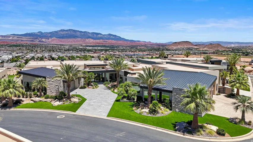 Contemporary residence featuring multiple rooflines, stone accents, and a paver driveway