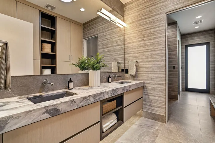 Dual vanity featuring slab countertops, integrated sinks, and wall-mounted faucets
