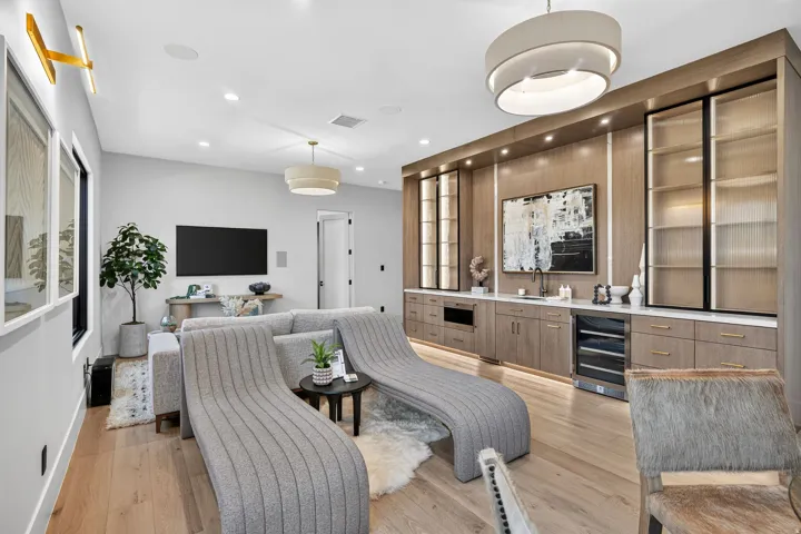 Built-in cabinetry with integrated lighting, a beverage refrigerator, and open shelving with fluted glass doors