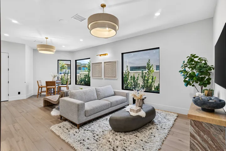 Open-concept living space with light wood-finish flooring, white walls, and recessed lighting