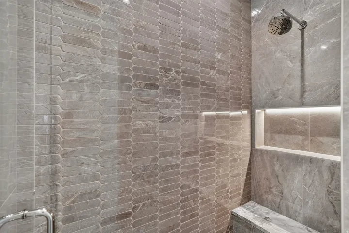 Walk-in shower featuring a rain showerhead, recessed lighting, and a built-in bench