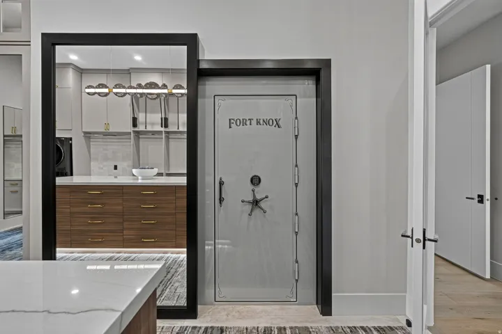 Custom-designed safe door with a star-shaped handle, set within a black frame, beside an open doorway