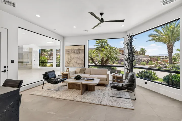 Expansive living area featuring large format tile flooring and a contemporary ceiling fan