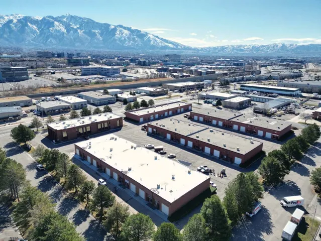 Industrial complex featuring multiple brick-exterior buildings with flat roofs and roll-up doors