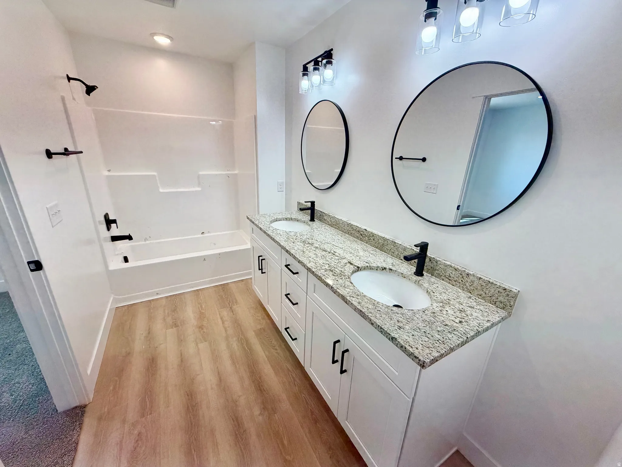 Dual vanity with granite countertops, undermount sinks, and matte black fixtures