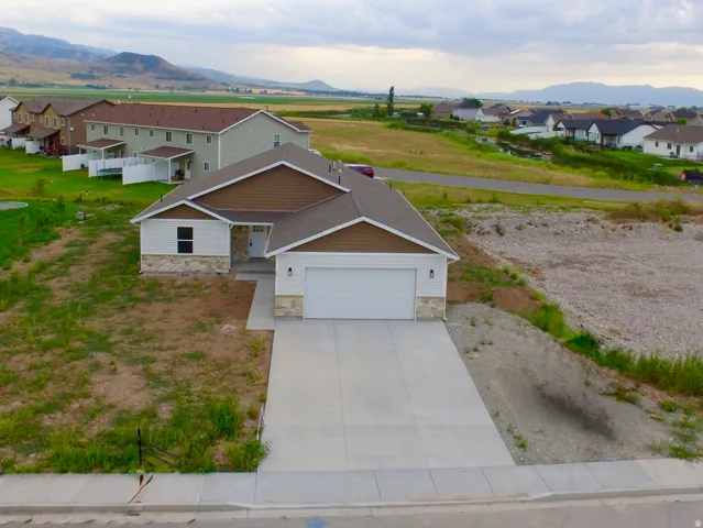 Single-story residence featuring a two-car garage, concrete driveway, and stone accent siding
