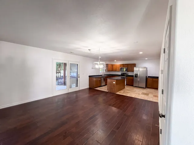 Open-concept kitchen and living area featuring dark wood-finish flooring
