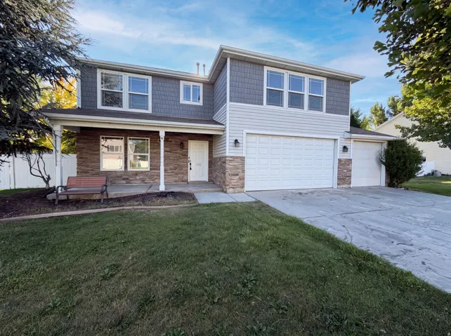 Two-story residence featuring a mixed-material exterior, a covered front porch, and a two-car garage