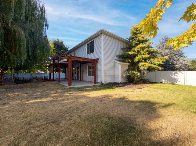 Rear exterior featuring a two-story design with horizontal siding, a concrete patio, and a wood pergola