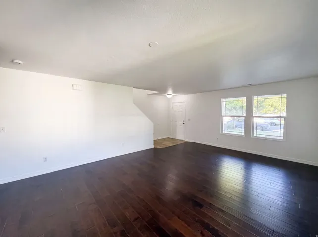 Spacious interior featuring dark wood-finish flooring and light-toned walls