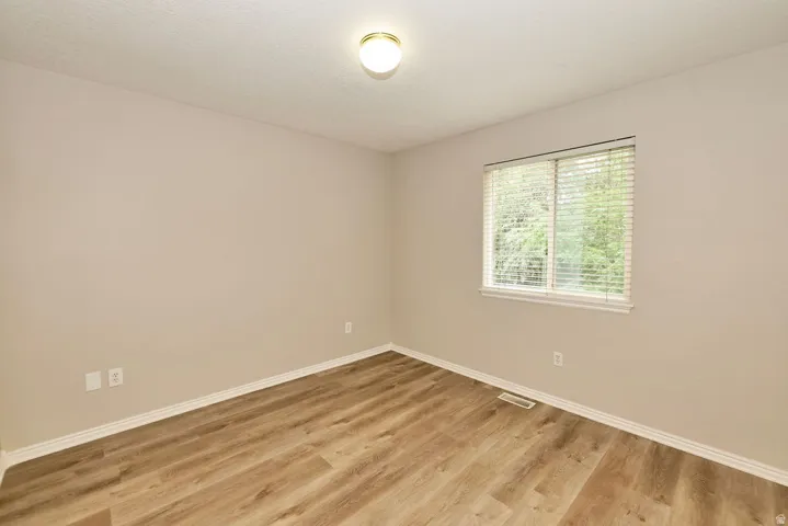 Light-filled interior space featuring wood-finish flooring, a neutral wall palette, and white baseboards