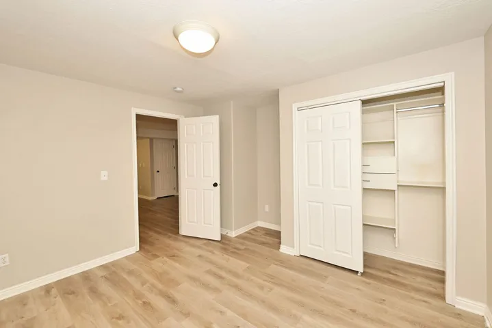 Room featuring light wood-finish flooring, neutral wall paint, and white baseboards