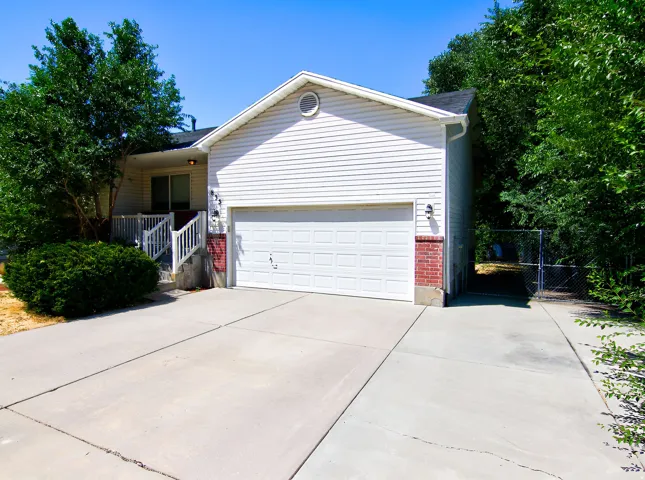 Residential exterior featuring white siding and a prominent two-car garage