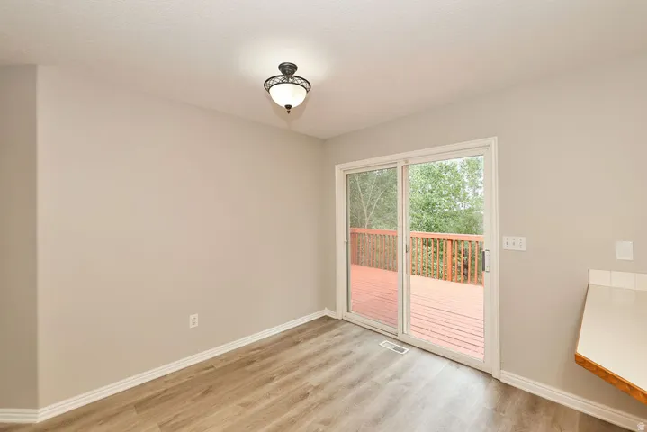 Interior space featuring wood-finish flooring, light-toned walls, and white baseboards