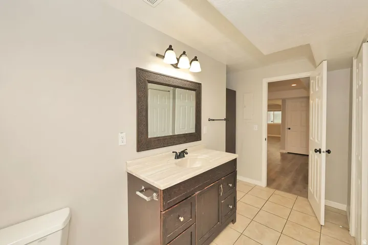 Bathroom vanity featuring a dark wood-finish cabinet with multiple drawers and a light-colored countertop
