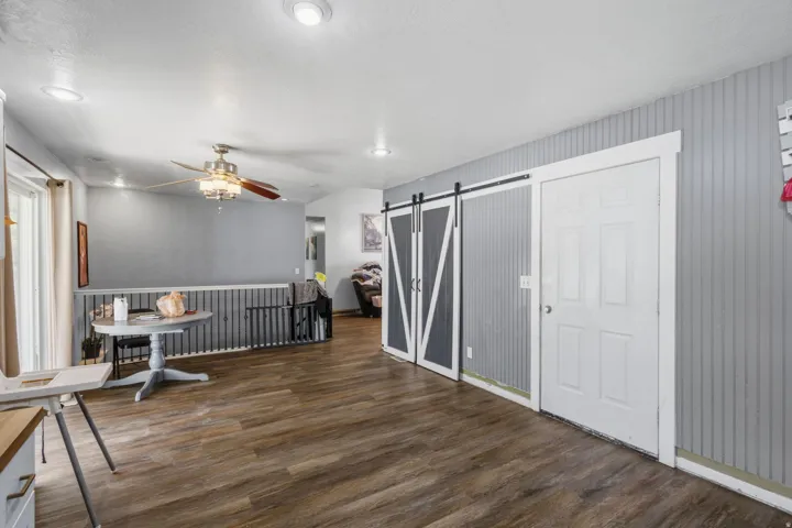 Wood-finish flooring throughout, complemented by recessed lighting and a ceiling fan