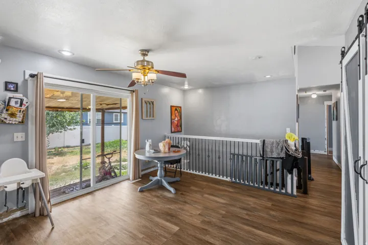 Spacious interior featuring wood-finish flooring, a ceiling fan with integrated lighting, and recessed lighting
