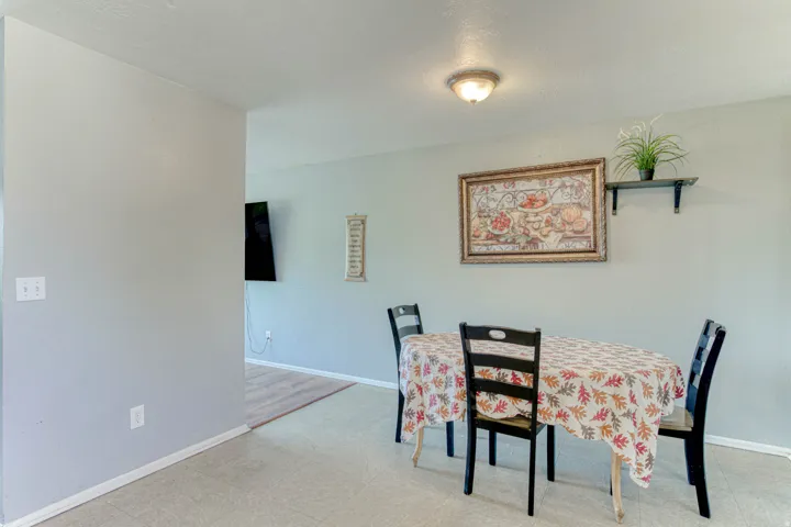 Dining area featuring neutral wall tones, recessed ceiling lighting, and a wall-mounted floating shelf