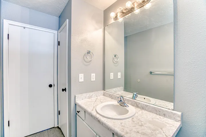 Vanity with a white, integrated sink and a stone-finish countertop