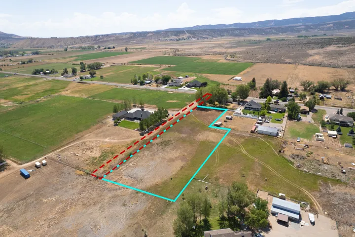 Expansive rural acreage featuring multiple outbuildings, mature tree lines, and cleared development potential