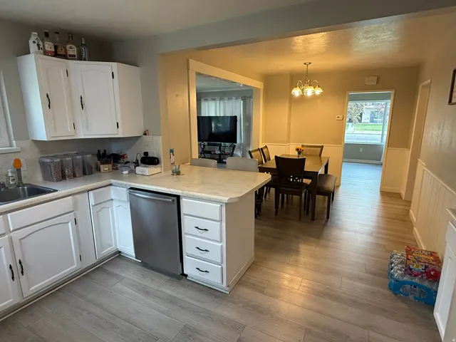 Kitchen featuring white cabinetry, light-toned countertops, and a stainless steel dishwasher